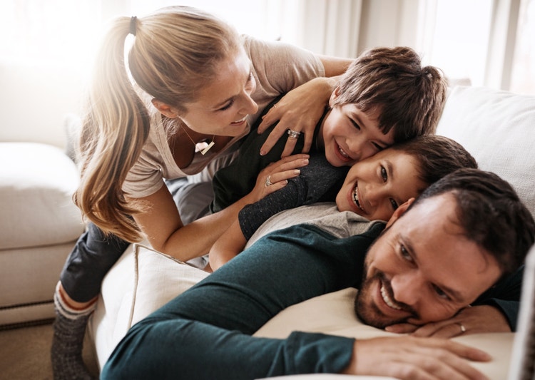 Famiglia con due bambini che gioca e ride insieme